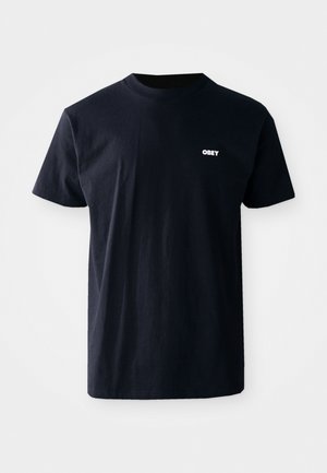 Camiseta de algodón azul marino con mangas cortas y cuello redondo, con un logo blanco que dice "OBEY" en el área del pecho izquierdo.