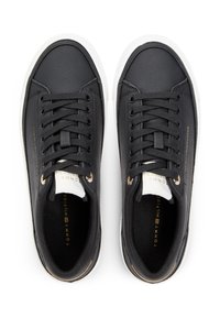 Μαύρα δερμάτινα αθλητικά παπούτσια με λευκές καουτσούκ σόλες, με στρογγυλά κορδόνια, λεπτομέρειες σε χρυσό τόνο και υφασμένο πάνω μέρος. Το λογότυπο της μάρκας είναι ανάγλυφο στο πλάι.