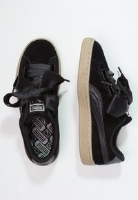 Czarne zamszowe sneakersy z przerośniętymi czarnymi satynowymi sznurówkami, beżową gumową podeszwą i wzorzystym czarnym wnętrzem z logo Puma.
