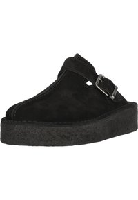 Svarta mocka slip-on skor med rund tå, sidospänne och en texturerad svart plattformssula.