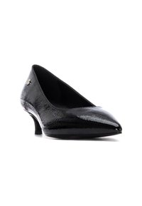 Zapatos de charol negro con punta afilada y un tacón bajo. Presenta un acabado texturizado y un acento de hardware decorativo en el costado.