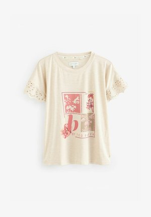 Beige t-paita lyhyillä hihoilla, jossa on pitsireunus, etupuolella vaaleanpunainen ja harmaa kukkakuva, valmistettu pehmeästä ja kevyestä kankaasta.