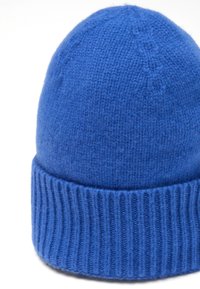 Gorro de punto azul hecho de lana, con un puño acanalado y un cuerpo liso con la parte superior redondeada. La textura es suave y cálida.