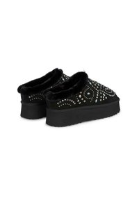 Czarne buty slip-on z teksturowanym futerkiem w środku, ozdobione dekoracyjnymi kamieniami szlachetnymi w różnych kształtach i rozmiarach, z grubą czarną podeszwą.