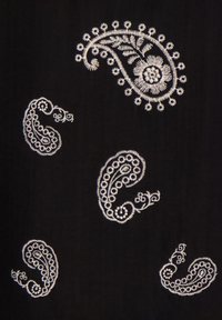 Zwarte stof met witte geborduurde paisley-motieven in verschillende groottes, met gedetailleerde bloem- en krulpatronen overal.