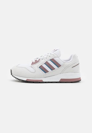 White athletic shoe with pink and blue stripes, suede and mesh materials, rounded toe, cushioned sole, and rubber outsole texture.