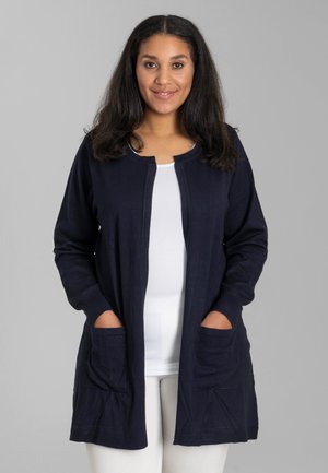 Cardigan lungo blu navy in morbido tessuto con scollatura tonda, apertura frontale e due tasche anteriori. Presenta polsini e orlo a coste.