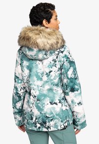 Bloemmotief, teal winterjack met een nepkraag van bont. Heeft een gewatteerd ontwerp en een iets langere achterkant voor extra bedekking.