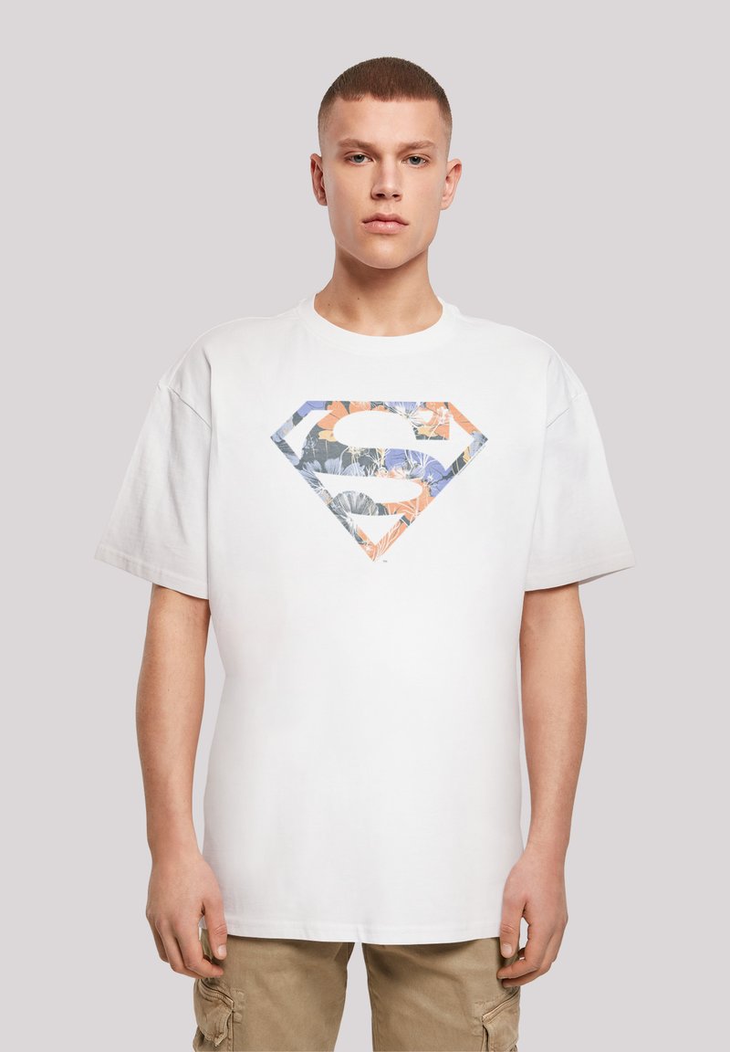 Hvit bomull t-skjorte med et stort, mønstret diamantlogo med blomsterdesign i blå, oransje og grønne toner på brystet.