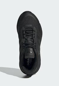Melnas sporta kurpes ar strukturētu auduma virsotni, plakaniem šņorēm, mīkstu apkaklīti un logotipa detaļu uz mēles. Izturīga gumijas zole.