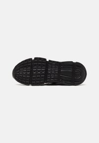 Suela de zapato atlético negro con patrones texturizados, secciones divididas y material de goma resistente para agarre y durabilidad.