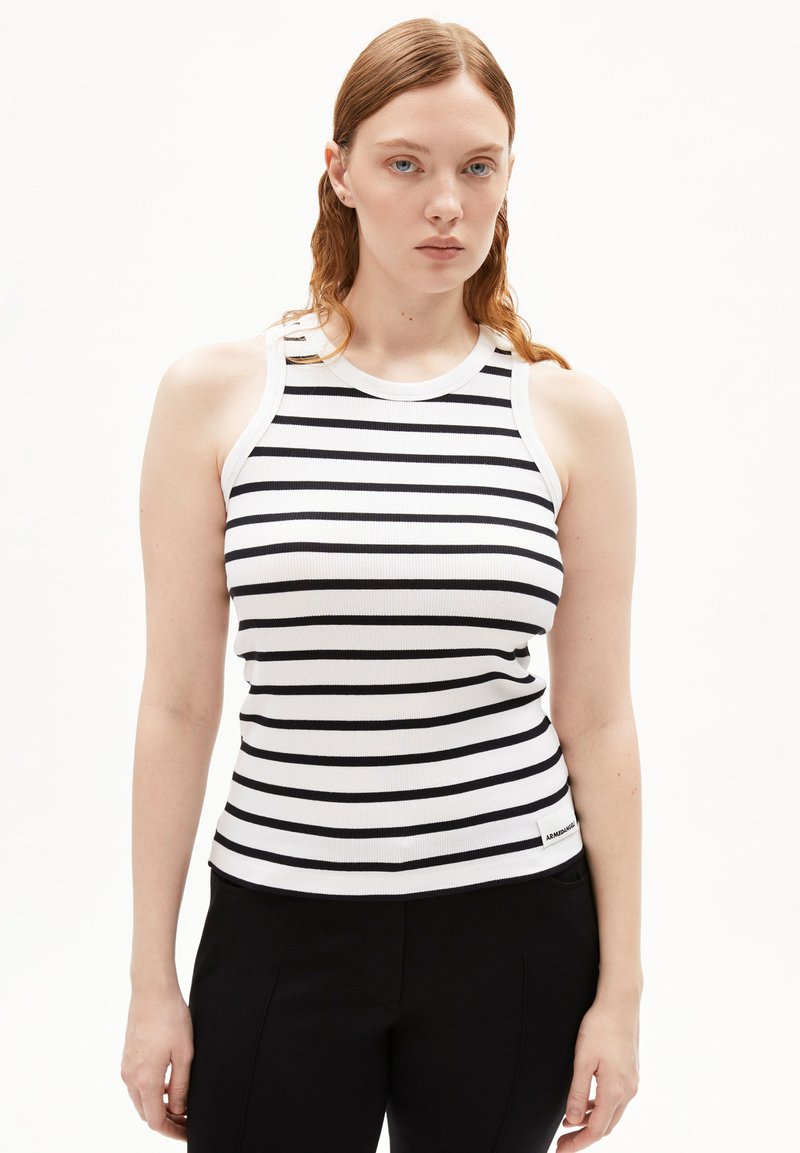 Top a righe bianco e nero con texture a costine e scollatura tonda, caratterizzato da un piccolo logo etichetta sull'orlo.
