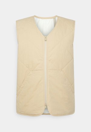 Gilet imbottito beige con scollo a V, design senza maniche, chiusura frontale con zip e texture morbida, caratterizzato da motivi di cucitura diagonale.