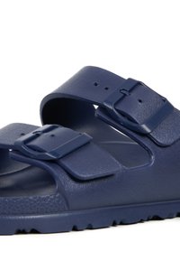 Sandales bleu marine avec deux brides réglables et boucles. Matériau texturé, semelle intérieure anatomique et semelle extérieure à motif pour une meilleure adhérence.