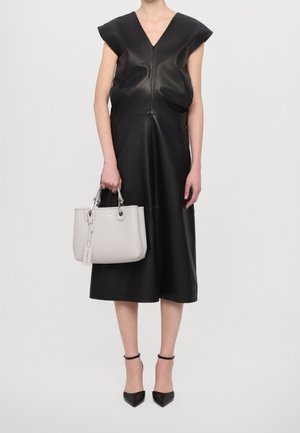 Černé kožené šaty s krátkými rukávy ve tvaru krátkých kapes, výstřihem do V a rozšířenou siluetou. Šedá kabelka s oblými držadly a visačkou, doplněná černými špičatými lodičkami.