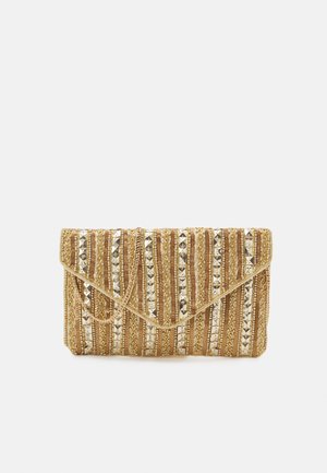 Pochette perlée or et argent avec motif à rayures verticales et bandoulière chaîne, posée sur un fond clair uni.