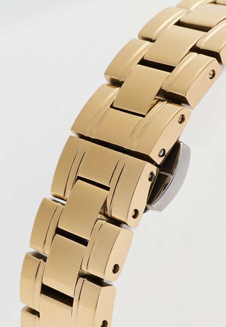 Goldfarbener Metall-Uhrenarmband mit flachen, rechteckigen Gliedern und glänzender Oberfläche sowie einem kleinen silbernen Verschluss. Glatte Textur und minimalistisches Design.