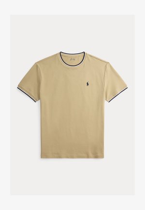 Beżowy bawełniany t-shirt z okrągłym dekoltem, granatowym wykończeniem kołnierza i rękawów oraz małym granatowym logo na lewej piersi. Gładka faktura.