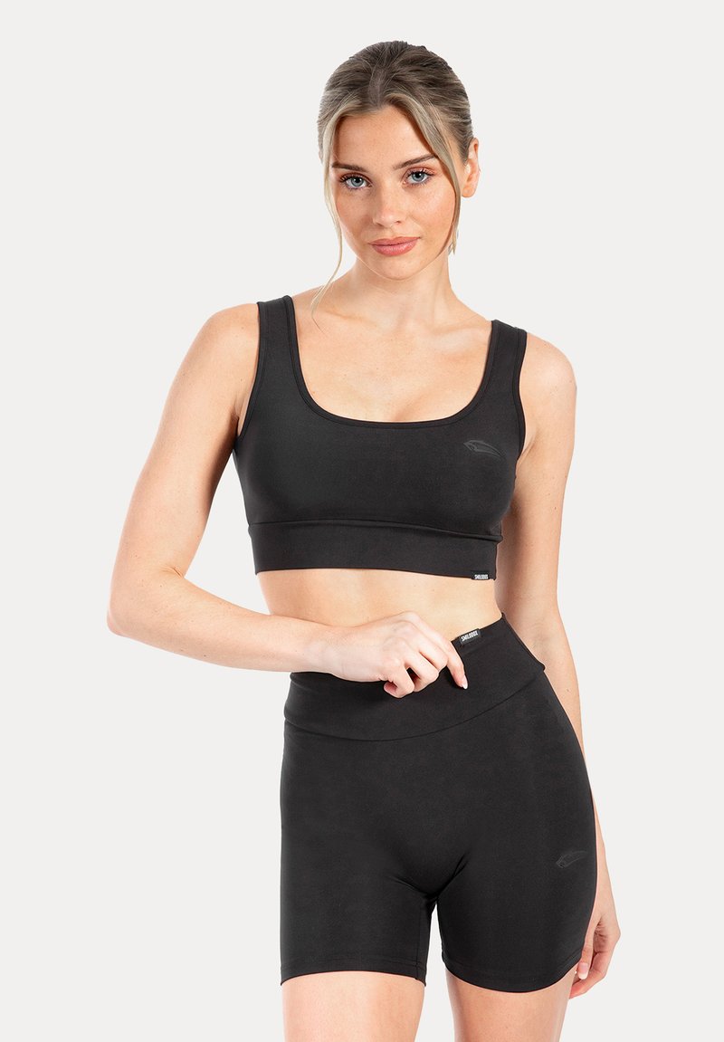 Zwarte atletische cropped top met een ronde halslijn en brede bandjes, gecombineerd met zwarte shorts met hoge taille, gemaakt van een gladde, rekbare stof.