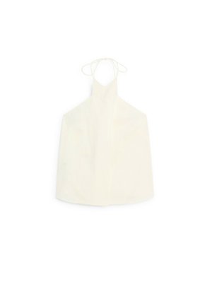 Haut halter blanc avec décolleté en V, fermeture à nouer au dos, et un tissu lisse légèrement texturé sans embellissements.