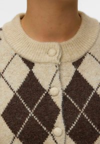 Cardigan in lana a trama argyle color crema e marrone con colletto a coste, due chiusure a bottone e tessuto testurizzato.