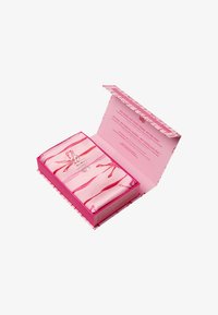 Rosa silkesje og putevar sett, med røde båndmønstre, i en rosa og hvitstripet eske, med produktdetaljer inni.