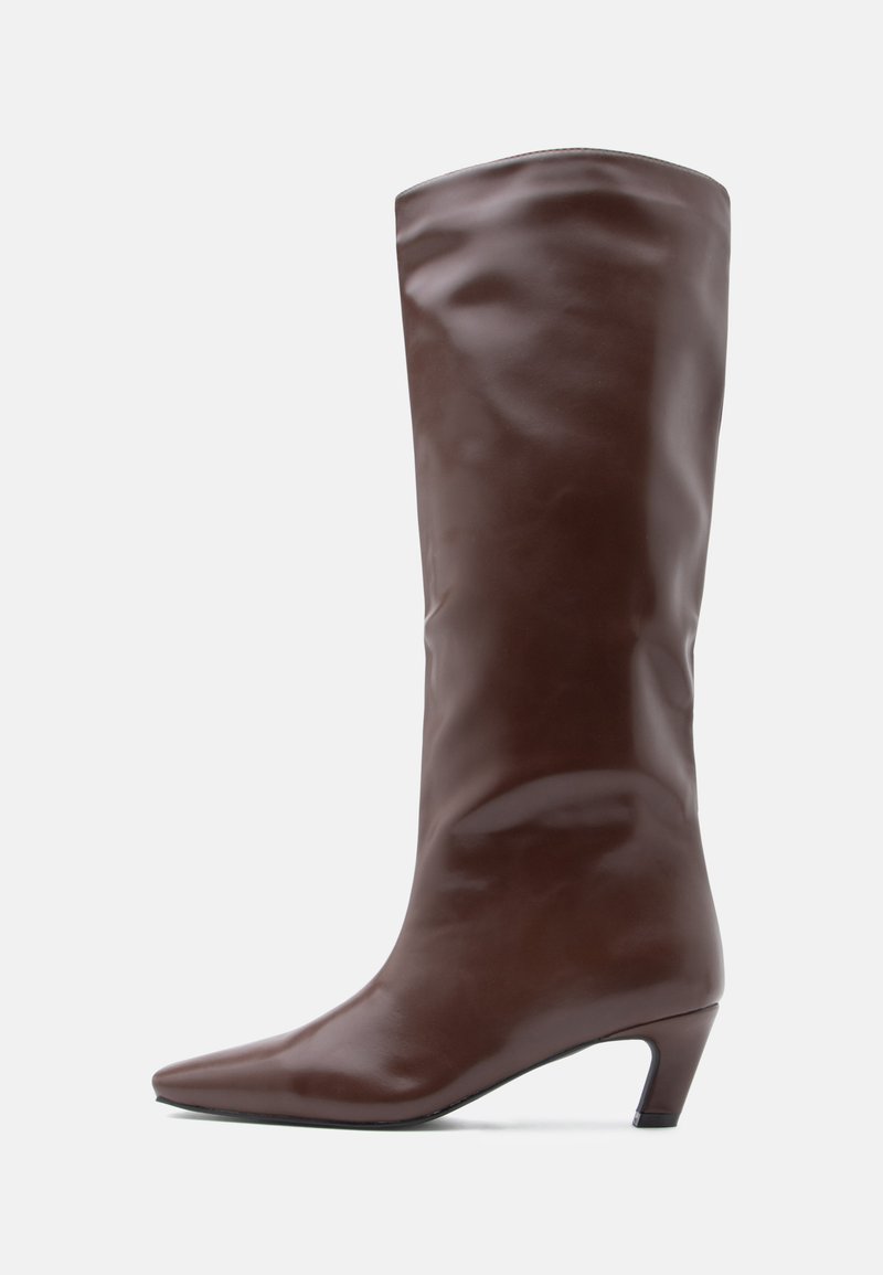 Botte en cuir brun montant jusqu'au genou, avec un bout pointu et un talon effilé. Texture lisse avec un design élégant et minimaliste.