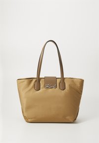 Sac fourre-tout en nylon marron avec deux poignées robustes, un fond plat, et une plaque de logo à l'avant. Texture lisse avec une légère brillance.