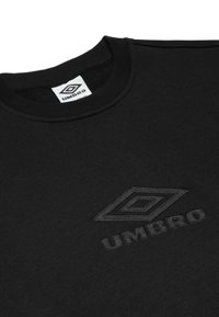 Felpa nera con colletto a girocollo, caratterizzata da un logo Umbro ricamato testurizzato in nero e da un'etichetta. Materiale in cotone, texture liscia.
