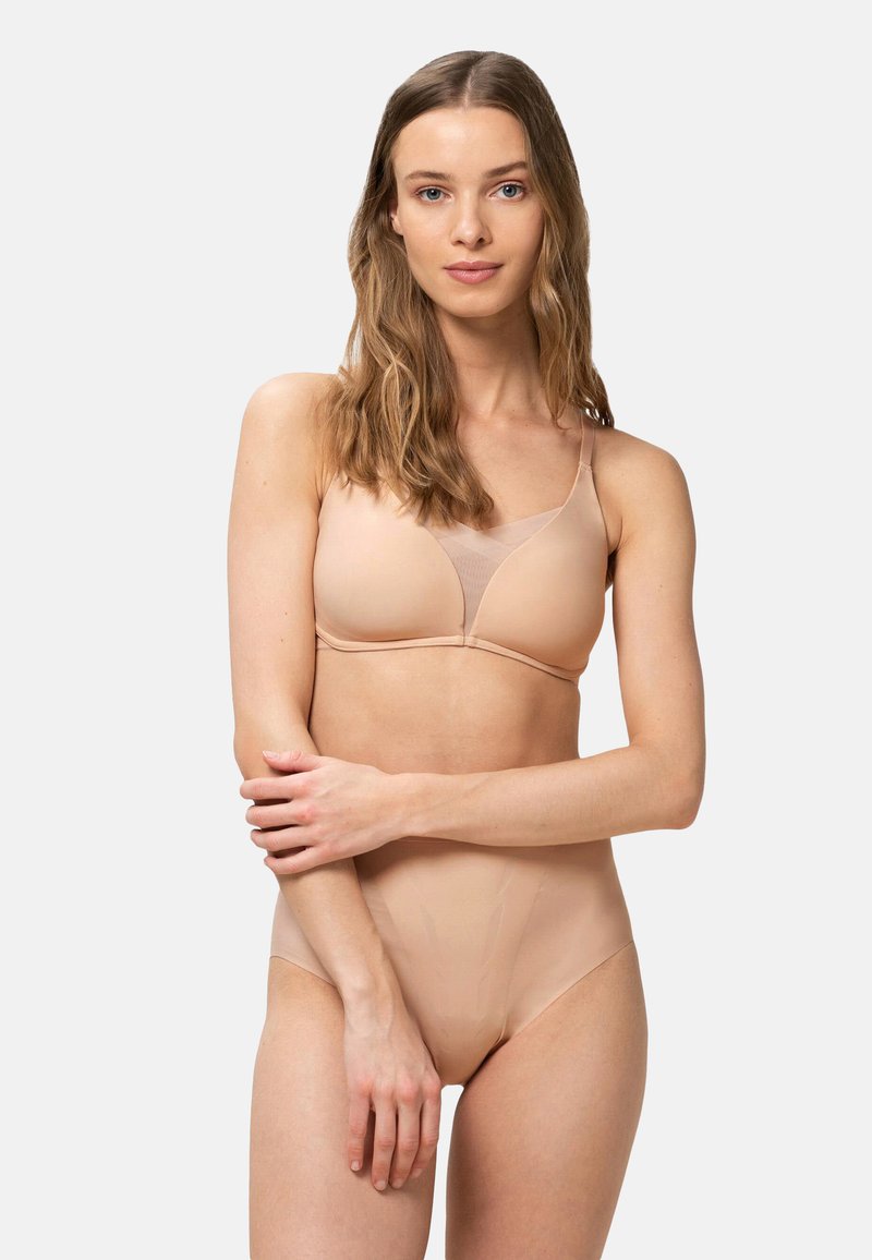Sujetador inalámbrico en tono nude con un acabado suave y detalles de malla transparente. Braguitas de cintura alta a juego en un tono similar, ambas hechas de tela suave.