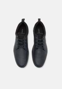 Mörkblå läderskor med en strukturerad yta, rund tå, snörningsdesign och dragflik på hälen, med en svart inredning.