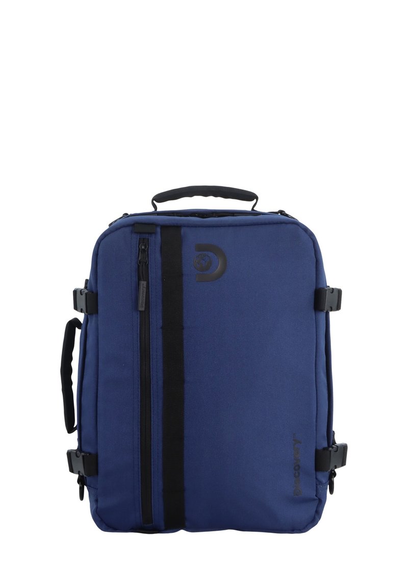 Mochila de tela azul con un asa superior, correas laterales, un cierre negro y detalle de logo en la parte frontal. Forma rectangular con un acabado texturizado.