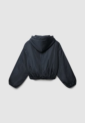 Giacca cropped nera con cappuccio, dotata di vita e polsini elasticizzati, vista da dietro su uno sfondo grigio chiaro uniforme.