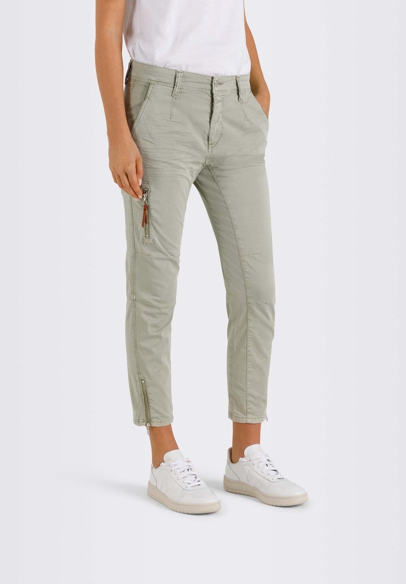 Ljusgrå tapered byxor med fram- och sidofickor, dragkedjedetaljer och en bekväm passform, matchade med vita sneakers.