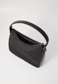 Black fabric handbag with a smooth texture, featuring a wide, rounded shape, a leather strap, and a zippered top closure.