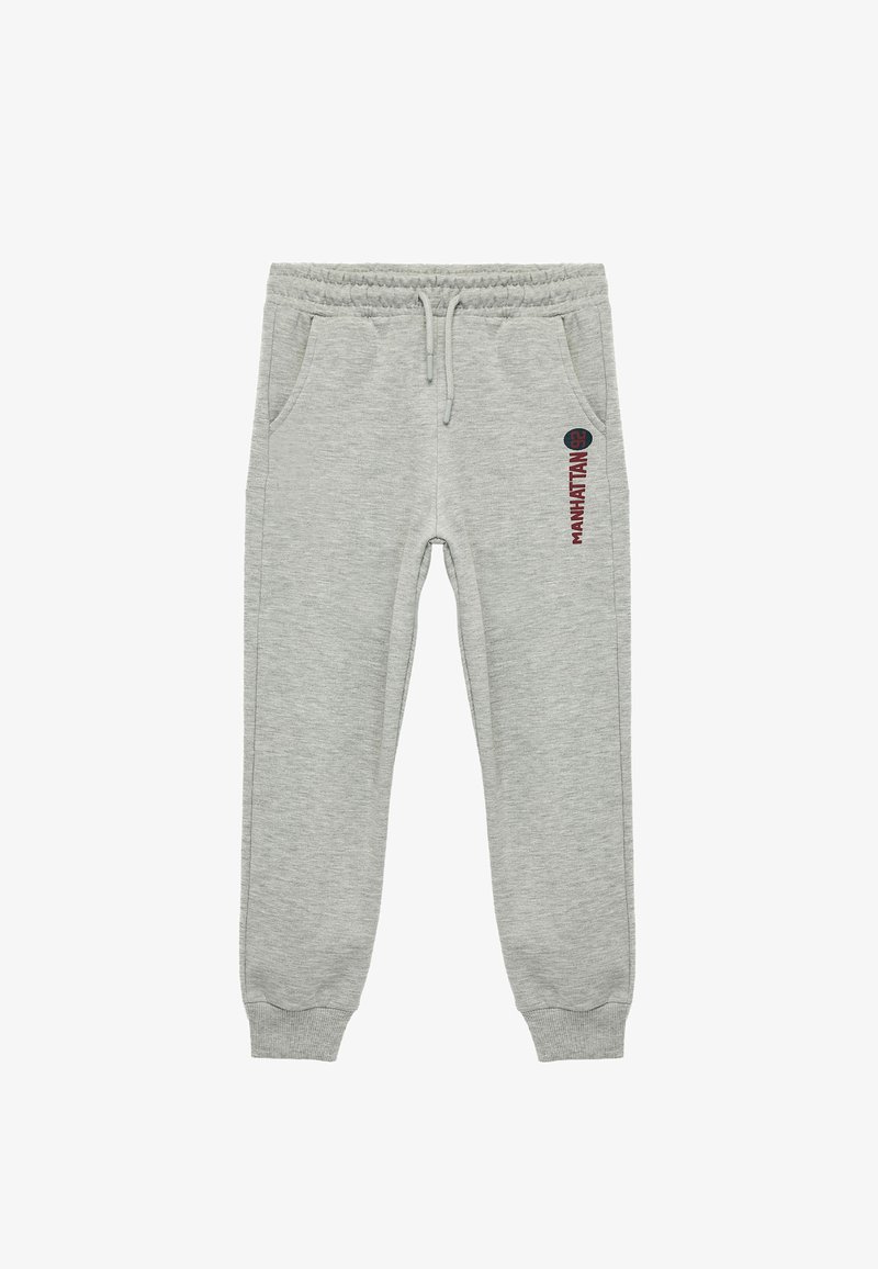 Grey sweatpants with elastic waistband, side pockets, and ribbed cuffs. Features "MANHATTAN" text in dark red on the side. Soft fabric texture.