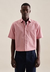 Kortarmig, knoopshirt in lichtroze met een subtiel streepjespatroon, enkele borstzak en witte knopen.