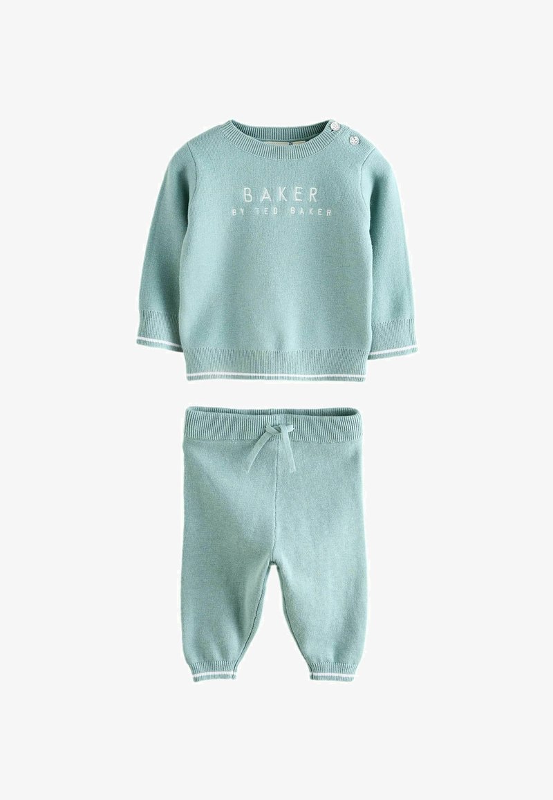 Hellblaues Strick-Babykleidungsset mit einem Pullover, der ein Logo auf der Vorderseite und Druckknöpfe hat, kombiniert mit passenden Hosen, die einen Kordelzugbund haben.