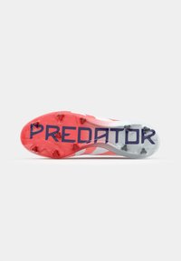 Suola di scarpini da calcio neri e rossi con il testo "PREDATOR", tacchetti multicolore, una superficie in plastica liscia e un design aerodinamico.