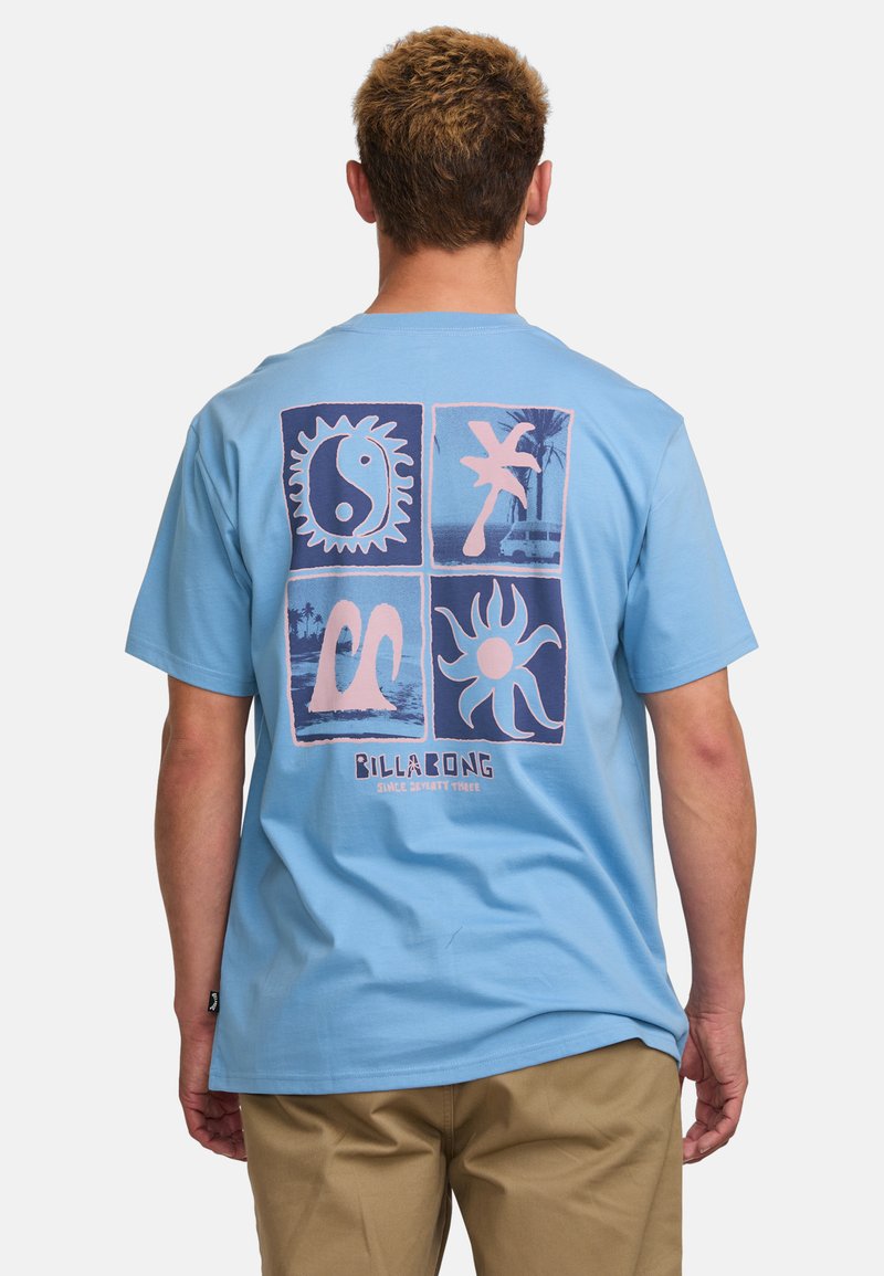 Vaaleansininen puuvillapaita, jossa on graafinen printti, jossa on neljä neliömuotoa, mukaan lukien aurinko- ja aaltoaiheita, sekä "Billabong"-logo.