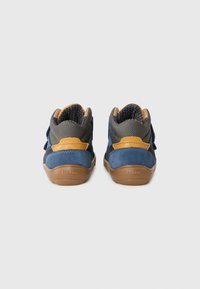 Chaussures en cuir bleu avec des accents textiles gris, semelles en caoutchouc marron et sangles jaunes. La vue de dos met en avant le design montante et les matériaux texturés.
