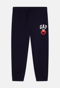 Marineblå sweatpants med elastisk talje og snor. Udstyret med ordet "GAP" og et rødt Elmo-print på forsiden. Lukket kantdesign.