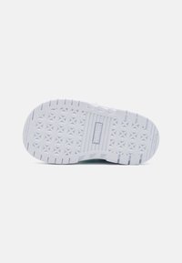 White sneaker sole with textured rubber pattern, featuring a logo detail and a non-marking design. Flat, wide shape with traction grooves.