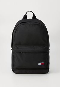 Černý nylonový batoh s předním kapsou na zip, nastavitelnými ramenními popruhy a logem s červenými, bílými a modrými akcenty.