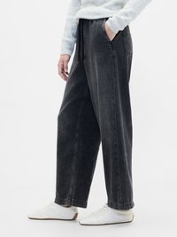 Pantalones de mezclilla negros de pierna ancha con un ajuste relajado, que cuentan con dos bolsillos laterales y una cinturilla elástica con cordón.