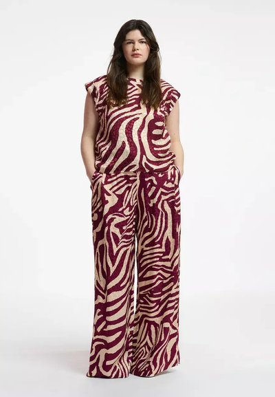 Conjunto de dos piezas que incluye una blusa de manga corta y pantalones de pierna ancha en un patrón de rayas de cebra en burdeos y crema. Tejido de textura suave.