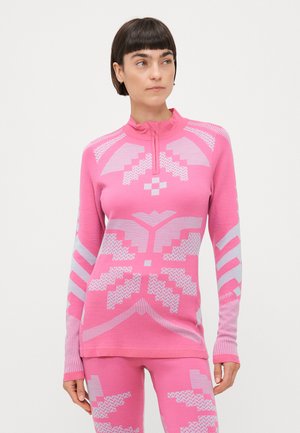 Rosa langermet topp med halvglidelås i halsen. Har geometriske hvite mønstre over hele. Myk tekstur, tettsittende design, lange ermer.