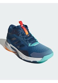 Modrá sportovní obuv s texturovaným textilem, bílou mezipodešví, mátově zelenými akcenty, červenou poutkou a výrazným vzorem gumové podešve.