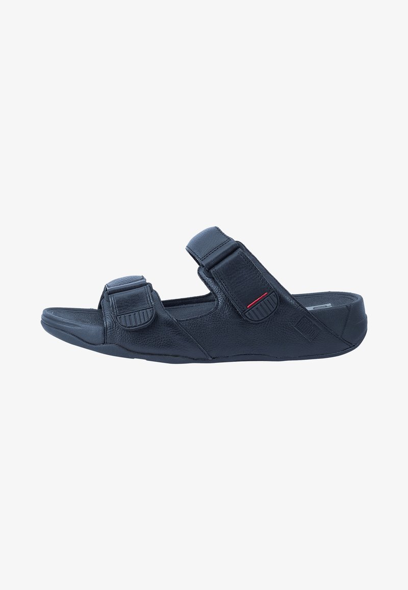 Black sandal with adjustable double straps, textured leather material, open toe, contoured footbed, and a slight heel for comfort.