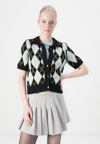 Černý kardigan s krátkým rukávem a geometrickým argyle vzorem ve světle modré a žluté barvě. Obsahuje límec, knoflíky a zkrácený střih.